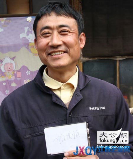 “的哥”郭立新在自家门口向记者展示他所称习总为他提写的“一帆风顺”原件 大公网记者王文韬摄　